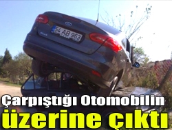 Çarpıştığı otomobilin üzerine çıktı